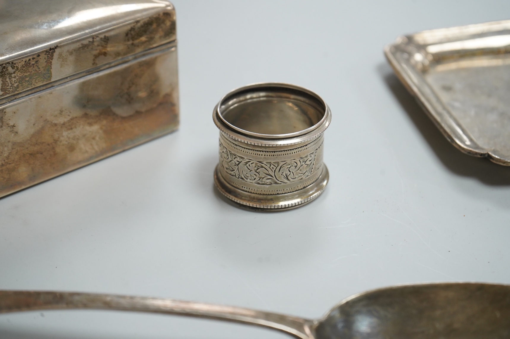A George VI silver mounted rectangular cigarette box, Atkin Brothers, London, 1944, 17.3cm, together with a small silver dish, William Comyns & Sons Ltd, London, 1945, an Edwardian silver napkin ring and a George III sil